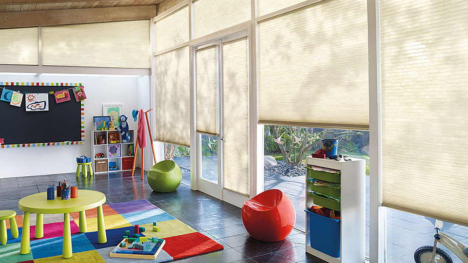 Playroom with solar shades one at each window set at various heights