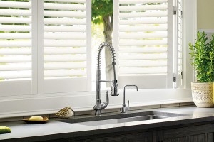 White Polysatin Plantation-style shutters one partly open over a kitchen sink