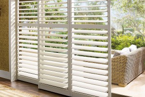 White Polysatin Plantation-style shutters looking out at an outdoor seating area