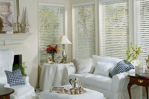 2 inch White faux wood blinds in sitting room, behind a white easy chair