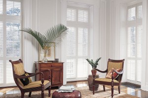 White wood shutters in sitting area with two antique wood chairs